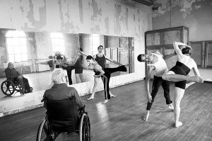 康寧漢坐在輪椅上看舞團成員排練。