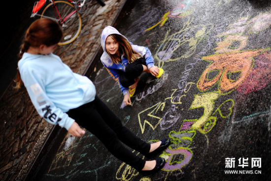 6月14日，在美國紐約曼哈頓第五大道，兩個女孩在路面上塗鴉。新華社記者申宏攝