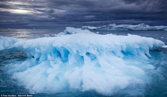 在格陵蘭伊盧利薩特一個暴風雨大作的傍晚，一座正在融化的冰山漂浮在雅各布峽灣附近