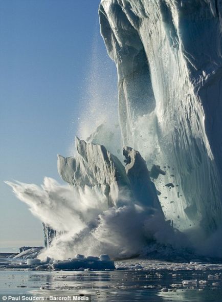 在格陵蘭伊盧利薩特的一個陽光明媚的夏季傍晚，一大塊冰從一座冰山上脫落下來