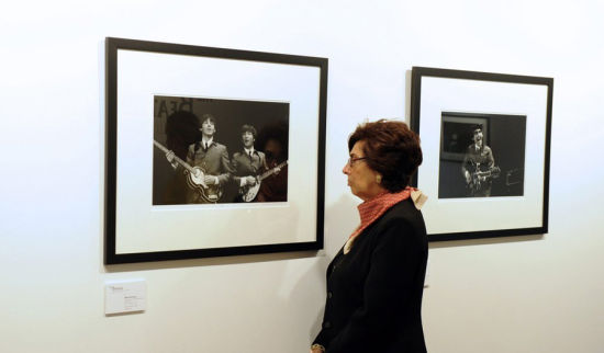 一名妇女在克利斯蒂拍卖行观赏展出的披头士乐队演出照片