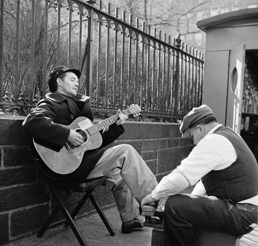 1943年，伍迪在街头擦鞋时仍在弹奏吉他