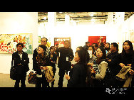     台湾画廊协会前秘书长陆洁民（中）在博览会现场为观众进行讲解。       (图/文 许柏成)
