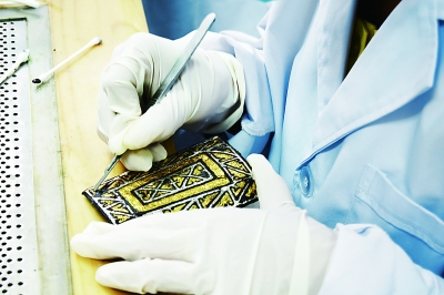 2013年7月18日，甘肃省考古研究所的专业人员正在实验室中修复马家塬战国墓地出土的车辆金属配件。光明日报记者 李韵摄